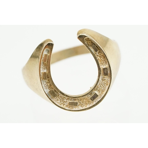 372 - 9ct gold horse shoe ring with moulded details. Hallmarked present but rubbed. Size S.5.