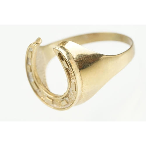 372 - 9ct gold horse shoe ring with moulded details. Hallmarked present but rubbed. Size S.5.