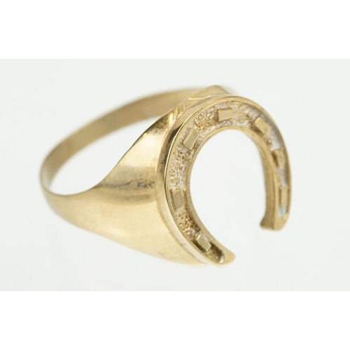 372 - 9ct gold horse shoe ring with moulded details. Hallmarked present but rubbed. Size S.5.