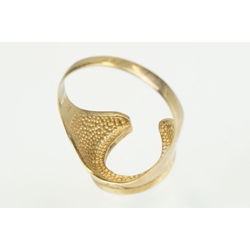 372 - 9ct gold horse shoe ring with moulded details. Hallmarked present but rubbed. Size S.5.