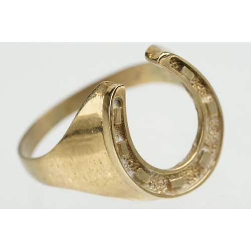 372 - 9ct gold horse shoe ring with moulded details. Hallmarked present but rubbed. Size S.5.