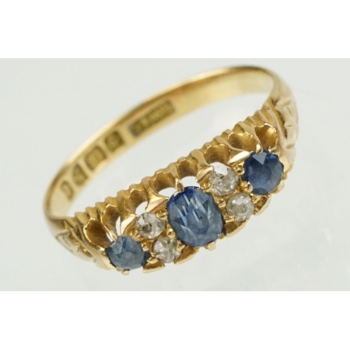 377 - Edwardian 18ct gold diamond and sapphire ring set with a central oval cut sapphire flanked by two ro... 