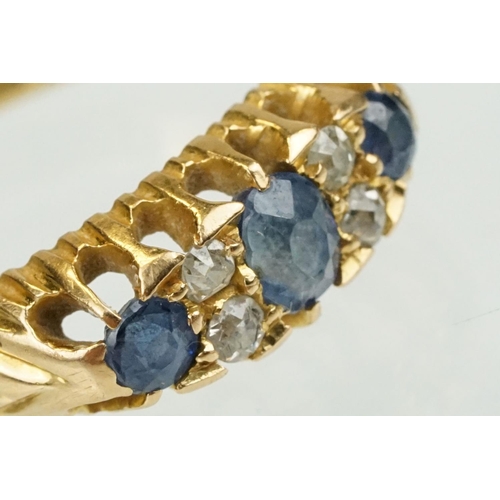 377 - Edwardian 18ct gold diamond and sapphire ring set with a central oval cut sapphire flanked by two ro... 