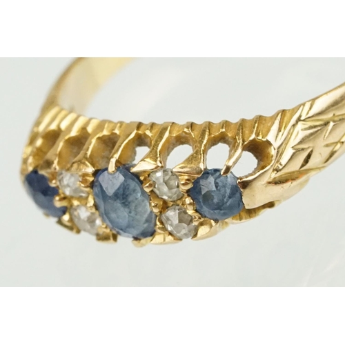 377 - Edwardian 18ct gold diamond and sapphire ring set with a central oval cut sapphire flanked by two ro... 