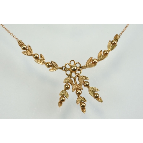 388 - 9ct gold vintage collar necklace having a foliate design centre mounted to fine chains with a spring... 