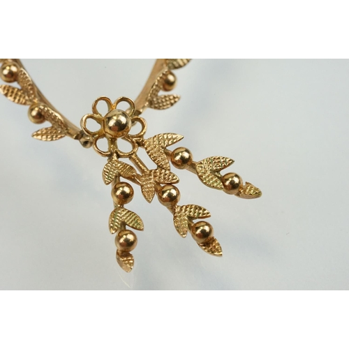 388 - 9ct gold vintage collar necklace having a foliate design centre mounted to fine chains with a spring... 