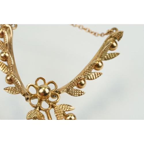 388 - 9ct gold vintage collar necklace having a foliate design centre mounted to fine chains with a spring... 