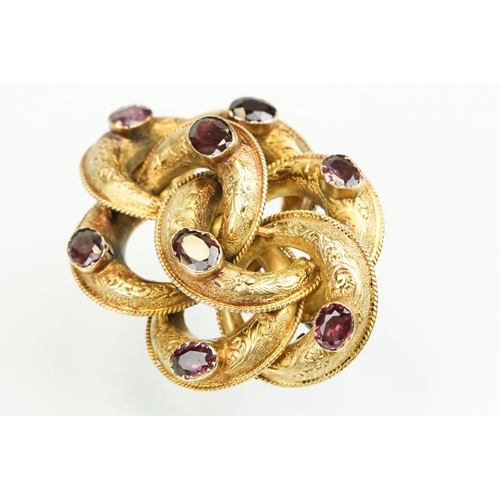 389 - 19th Century Victorian yellow metal knot brooch being bezel set with eight oval cut purple stones (u... 