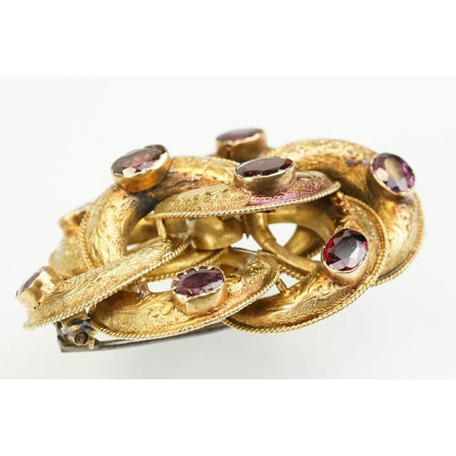 389 - 19th Century Victorian yellow metal knot brooch being bezel set with eight oval cut purple stones (u... 