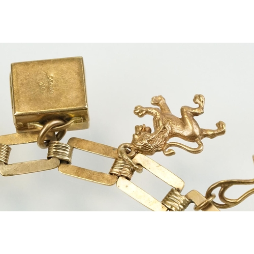 392 - 9ct gold charm bracelet having a square link bracelet chain with eight hallmarked 9ct gold charms. T... 