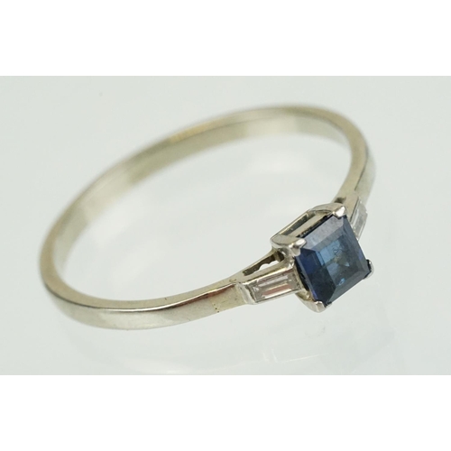 395 - Sapphire and diamond three stone ring set with a step cut blue sapphire flanked by two baguette cut ... 