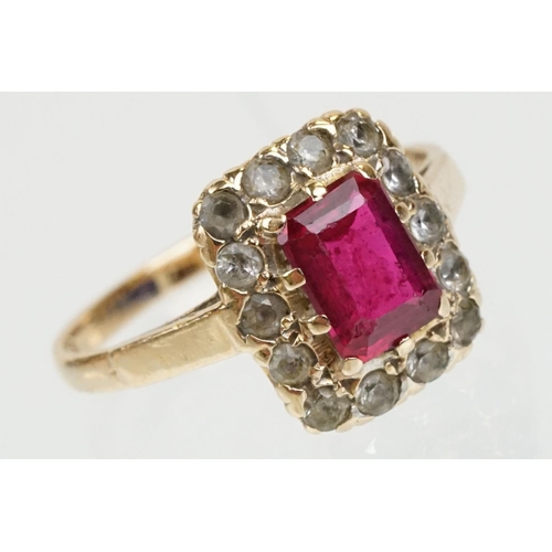 61 - 9ct gold hallmarked synthetic ruby and white stone cluster ring. The ring being set with a rectangul... 