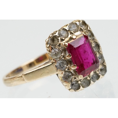 61 - 9ct gold hallmarked synthetic ruby and white stone cluster ring. The ring being set with a rectangul... 