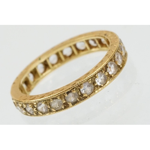 67 - 18ct and white stone eternity ring set with round cut white stones with incised detailing. Marked 18... 