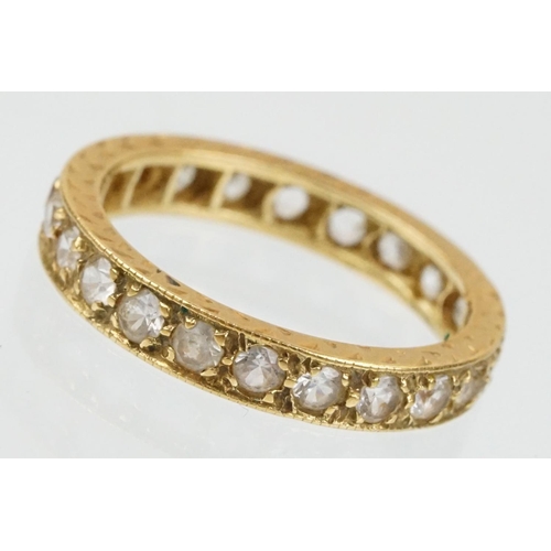 67 - 18ct and white stone eternity ring set with round cut white stones with incised detailing. Marked 18... 