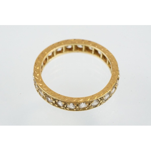 67 - 18ct and white stone eternity ring set with round cut white stones with incised detailing. Marked 18... 