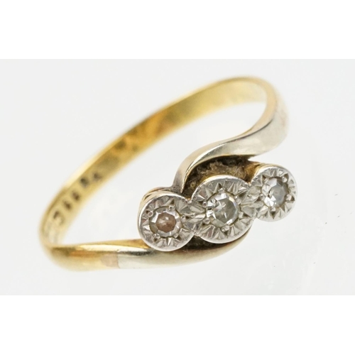 70 - 18ct gold and platinum three stone diamond cross over ring. The ring being illusion set with three s... 