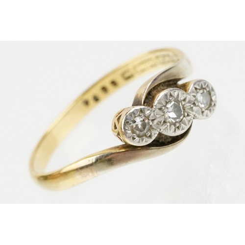 70 - 18ct gold and platinum three stone diamond cross over ring. The ring being illusion set with three s... 