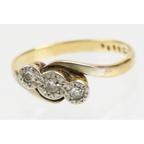 70 - 18ct gold and platinum three stone diamond cross over ring. The ring being illusion set with three s... 