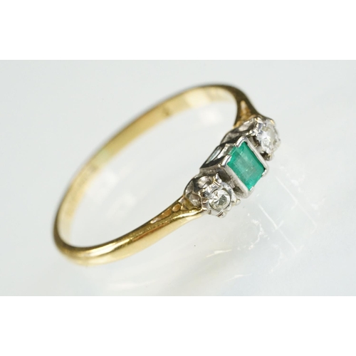 81 - 18ct gold emerald and diamond three stone ring. The ring being set with a step cut emerald flanked b... 