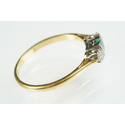 81 - 18ct gold emerald and diamond three stone ring. The ring being set with a step cut emerald flanked b... 