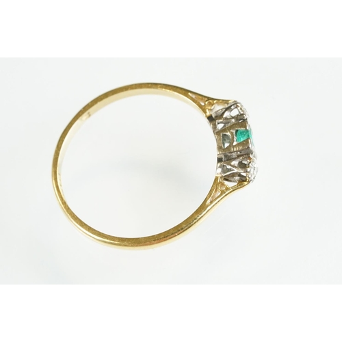 81 - 18ct gold emerald and diamond three stone ring. The ring being set with a step cut emerald flanked b... 