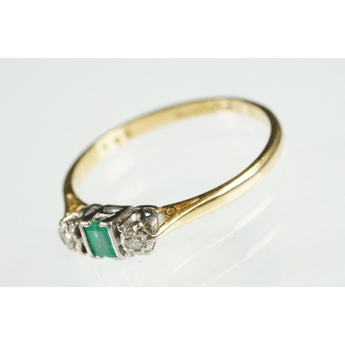 81 - 18ct gold emerald and diamond three stone ring. The ring being set with a step cut emerald flanked b... 