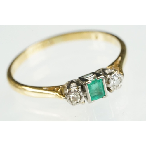 81 - 18ct gold emerald and diamond three stone ring. The ring being set with a step cut emerald flanked b... 