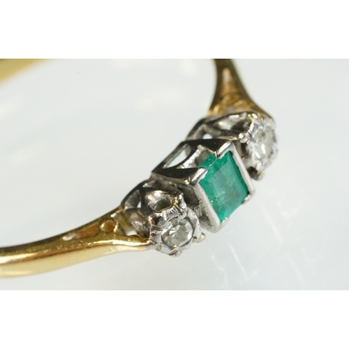 81 - 18ct gold emerald and diamond three stone ring. The ring being set with a step cut emerald flanked b... 