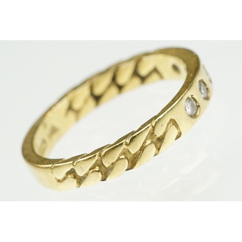 87 - 18ct gold and diamond band ring. The ring being set with five round cut diamonds with curb link deta... 