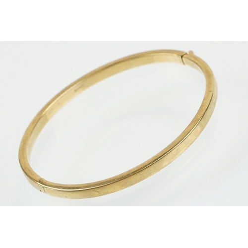 99 - Hallmarked 9ct gold hinged bangle bracelet of square curved form. Hallmarked Sheffield. Measures 6cm... 