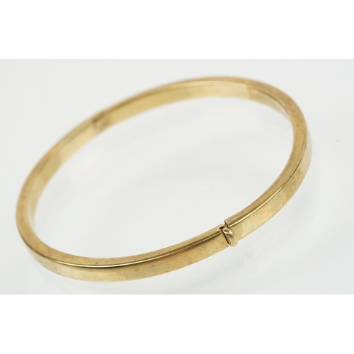 99 - Hallmarked 9ct gold hinged bangle bracelet of square curved form. Hallmarked Sheffield. Measures 6cm... 