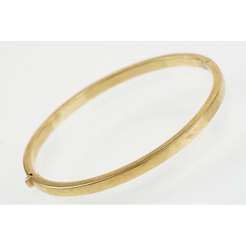 99 - Hallmarked 9ct gold hinged bangle bracelet of square curved form. Hallmarked Sheffield. Measures 6cm... 