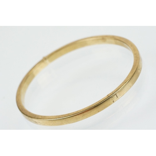 99 - Hallmarked 9ct gold hinged bangle bracelet of square curved form. Hallmarked Sheffield. Measures 6cm... 