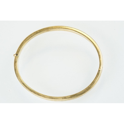 99 - Hallmarked 9ct gold hinged bangle bracelet of square curved form. Hallmarked Sheffield. Measures 6cm... 