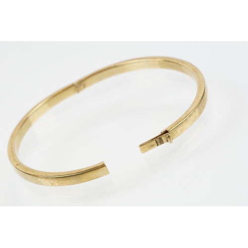 99 - Hallmarked 9ct gold hinged bangle bracelet of square curved form. Hallmarked Sheffield. Measures 6cm... 