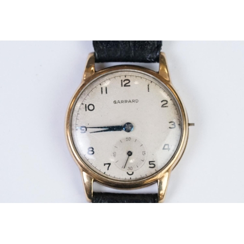 474 - A gents 9ct gold cased Garrard mechanical wristwatch, sub second dial to 6 o'clock, mounted to black... 