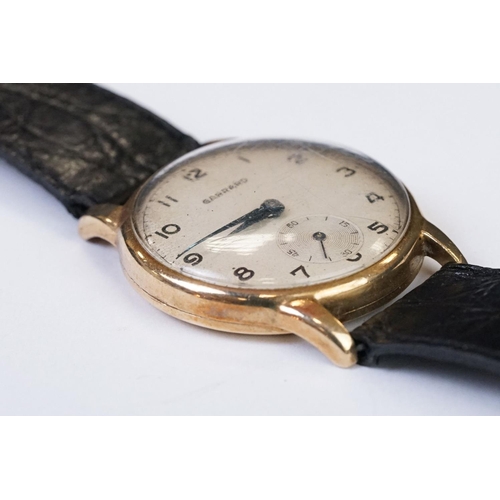 474 - A gents 9ct gold cased Garrard mechanical wristwatch, sub second dial to 6 o'clock, mounted to black... 