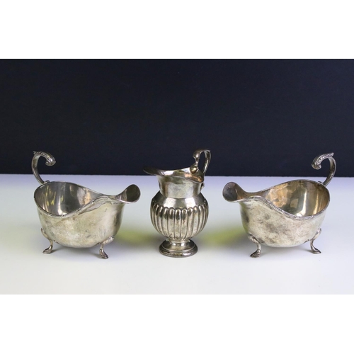 554 - Three silver hallmarked jugs to include a pair of Walker and Hall gravy jugs with moulded rims (hall... 