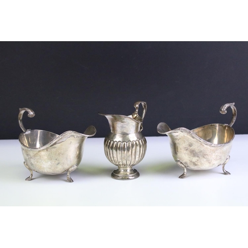 554 - Three silver hallmarked jugs to include a pair of Walker and Hall gravy jugs with moulded rims (hall... 