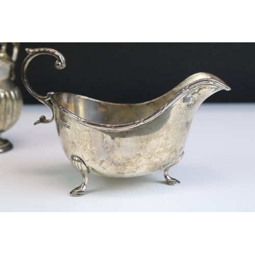 554 - Three silver hallmarked jugs to include a pair of Walker and Hall gravy jugs with moulded rims (hall... 