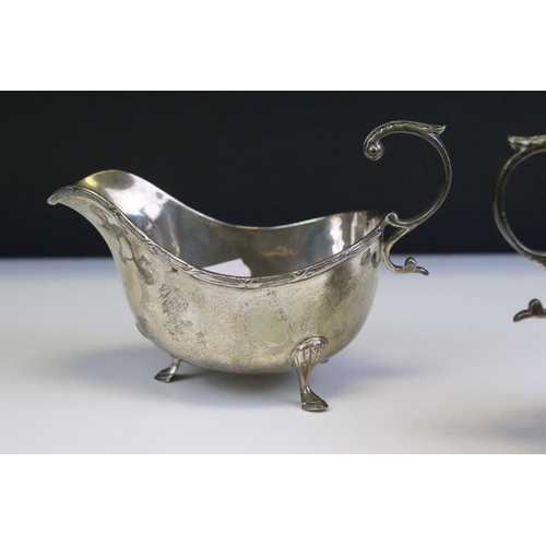 554 - Three silver hallmarked jugs to include a pair of Walker and Hall gravy jugs with moulded rims (hall... 