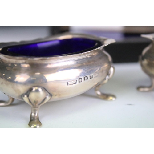 634 - Set of four George VI silver salt cellars, with shaped upper rims and blue glass liners, each raised... 