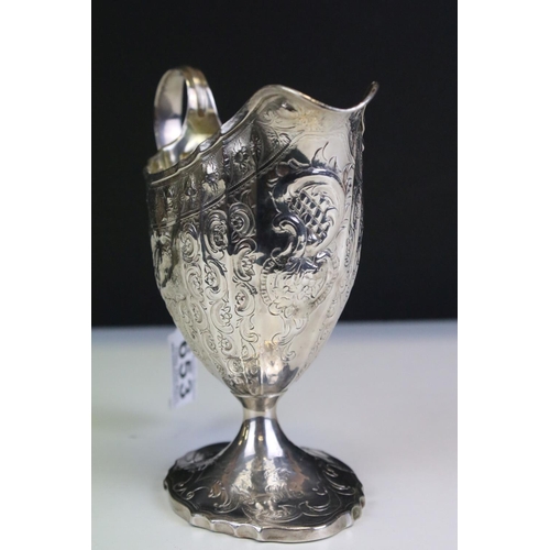 653 - 18th Century George III Scottish silver cream jug of helmet form having repousse scrolled detailing ... 