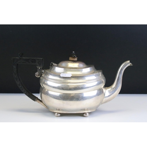 654 - Early 20th Century silver hallmarked tea pot having an ebonised wooden stirrup handle raised on ball... 