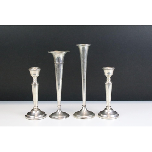 673 - Two silver stem vases together with a pair of silver candlesticks. Both stem vases marked sterling (... 