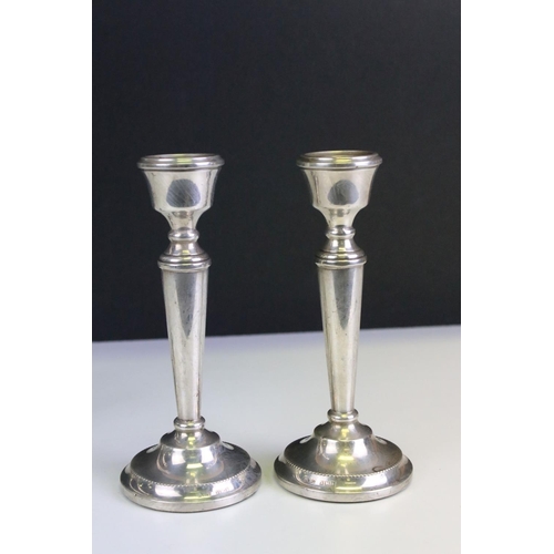 673 - Two silver stem vases together with a pair of silver candlesticks. Both stem vases marked sterling (... 