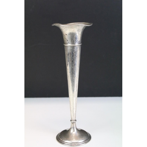 673 - Two silver stem vases together with a pair of silver candlesticks. Both stem vases marked sterling (... 