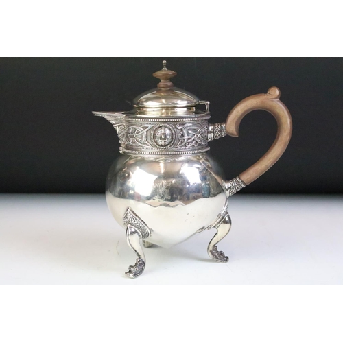 587 - Irish hot water pot silver having moulded Celtic design borders raised on scrolled feet, having a ca... 