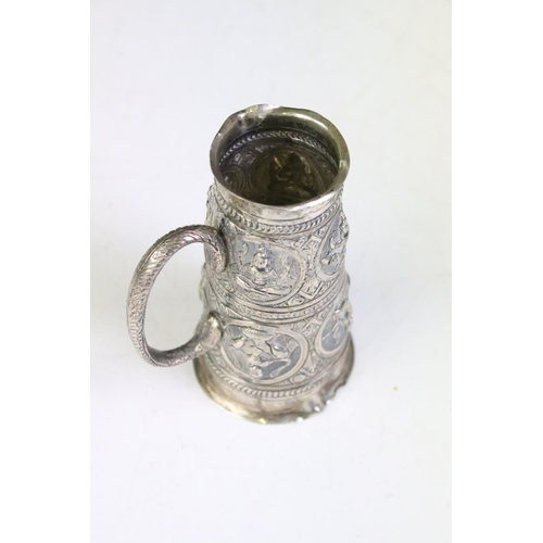 599 - 19th Century Indian silver white metal measure cup having repousse deities to the sides, of tapering... 